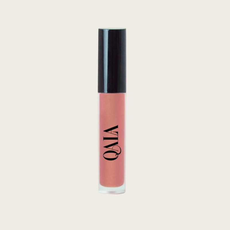 Close-up of QALA Lush Glow Liquid Lip Gloss in sleek recyclable packaging, showing radiant sheen and doe-foot applicator for precise, high-shine vegan lip color.