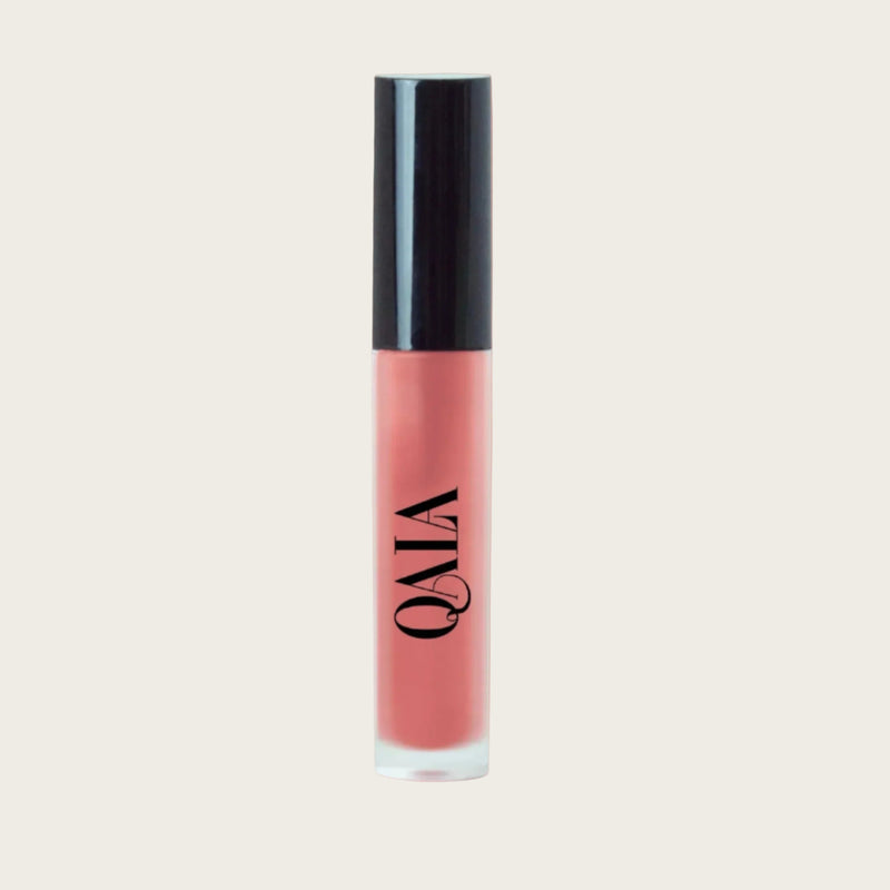 Close-up of QALA Lush Glow Liquid Lip Gloss in sleek recyclable packaging, showing radiant sheen and doe-foot applicator for precise, high-shine vegan lip color.