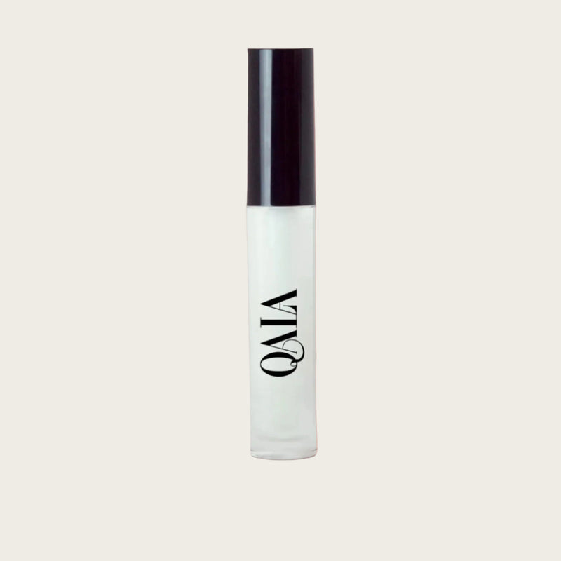 Close-up of QALA Lush Glow Liquid Lip Gloss in sleek recyclable packaging, showing radiant sheen and doe-foot applicator for precise, high-shine vegan lip color.